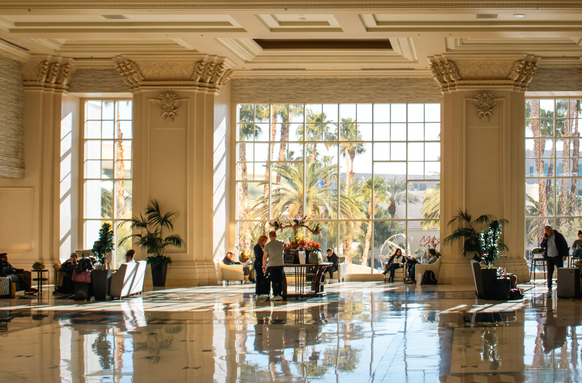 Bright hotel lobby with guests arriving