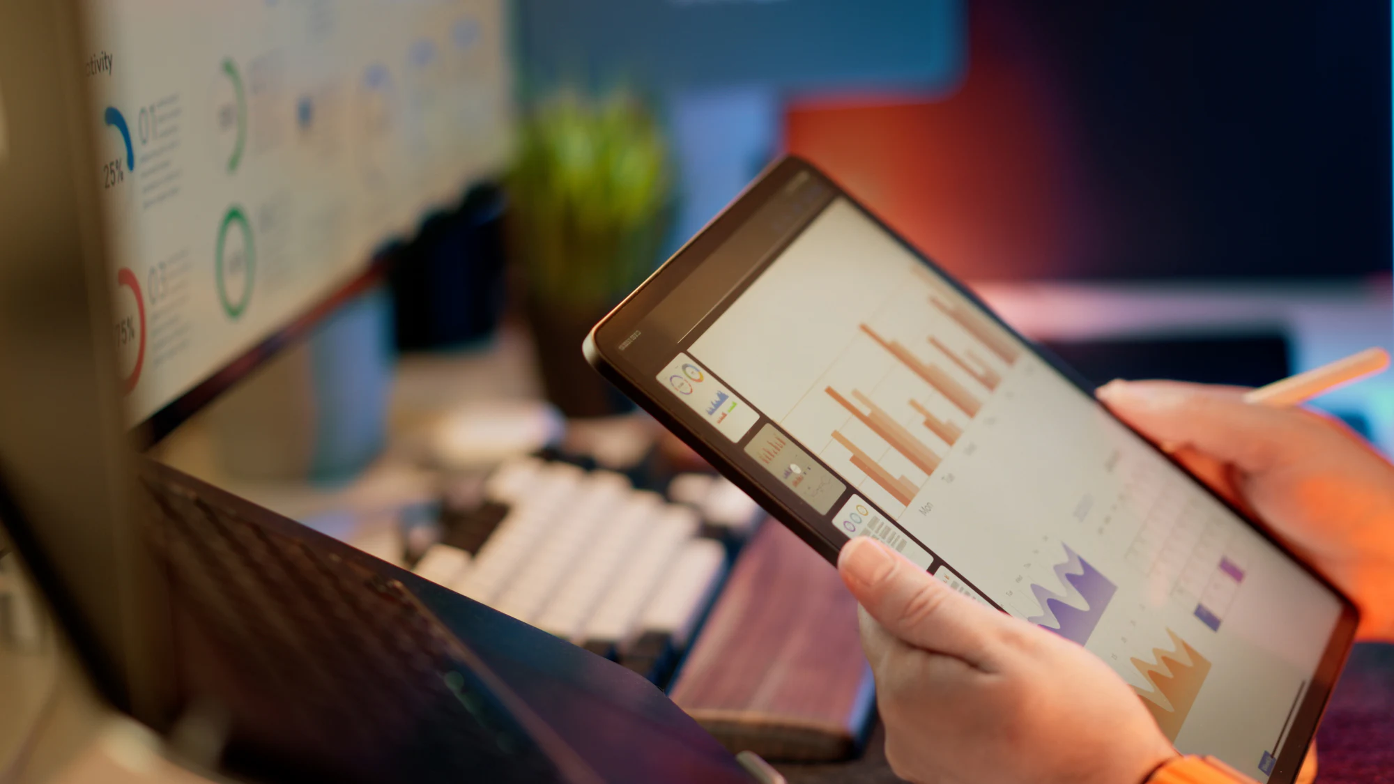 Hand holding a tablet with performance charts