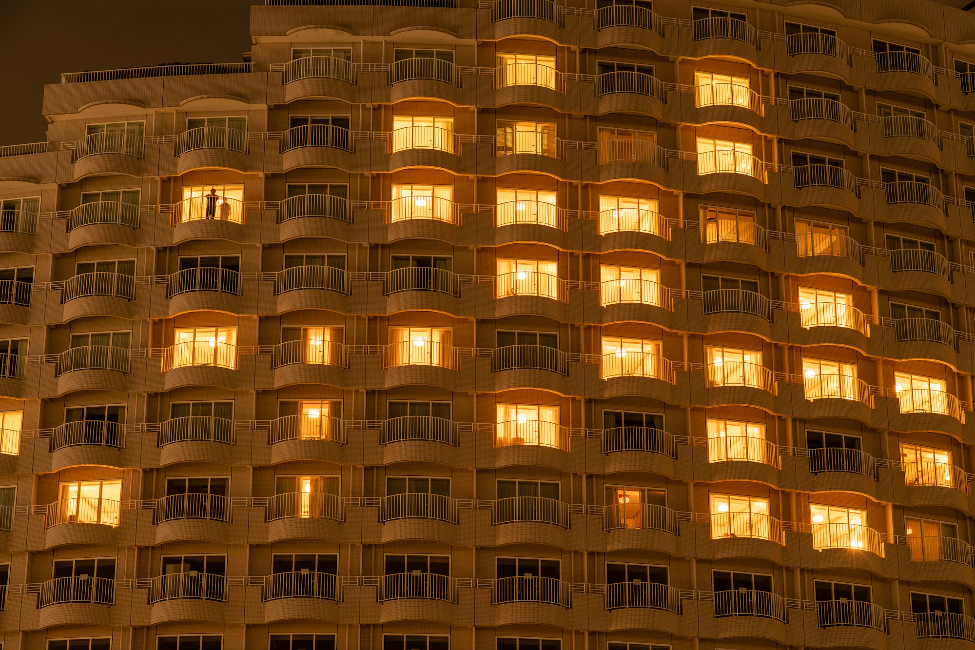 Hotel facade at dusk with many lit windows